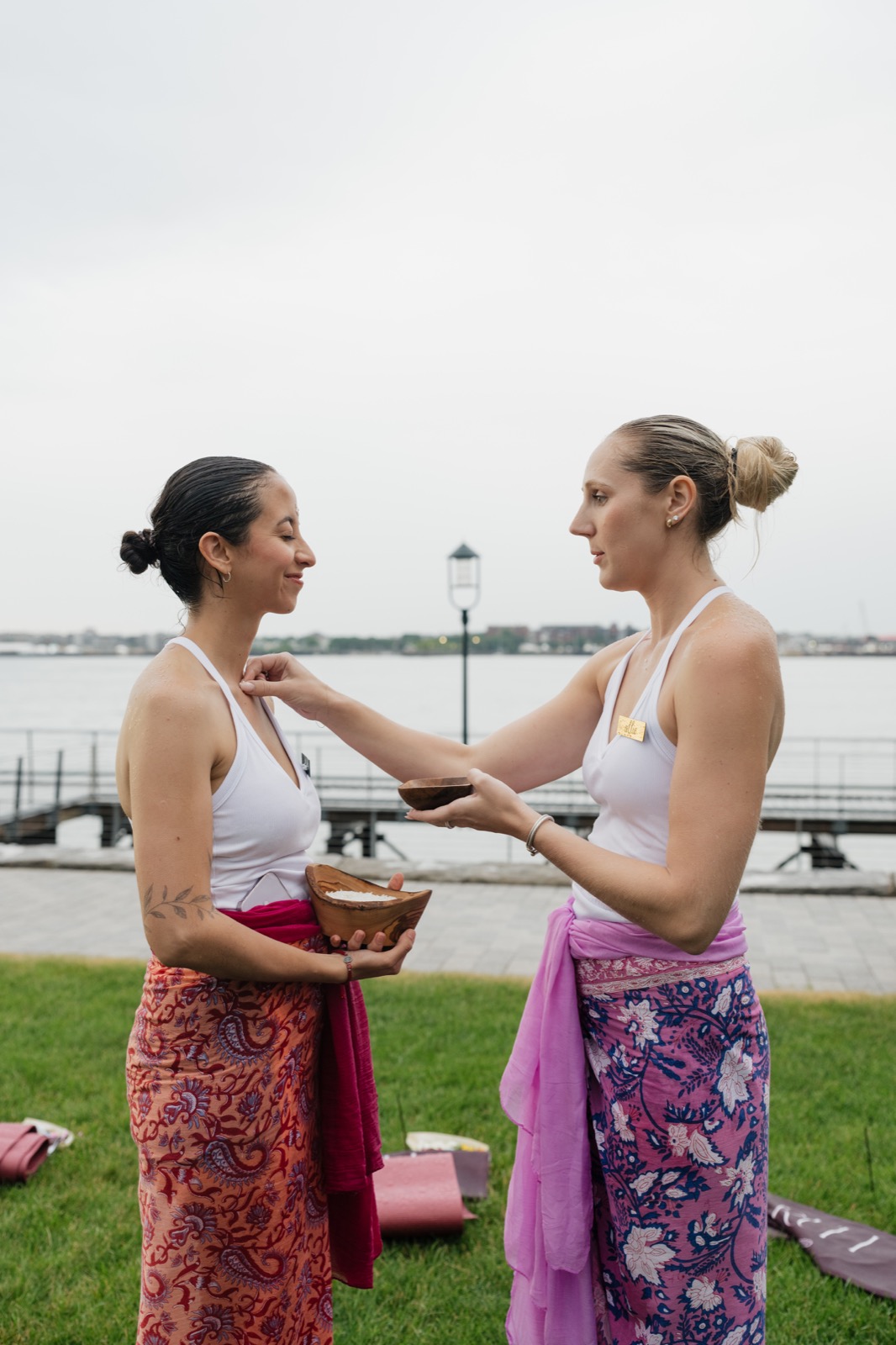 Women sharing a rice blessing by Boston Harbor